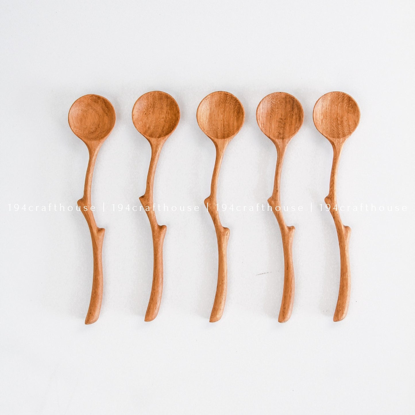 Collection of handcrafted branch handle wooden spoons showing natural variations