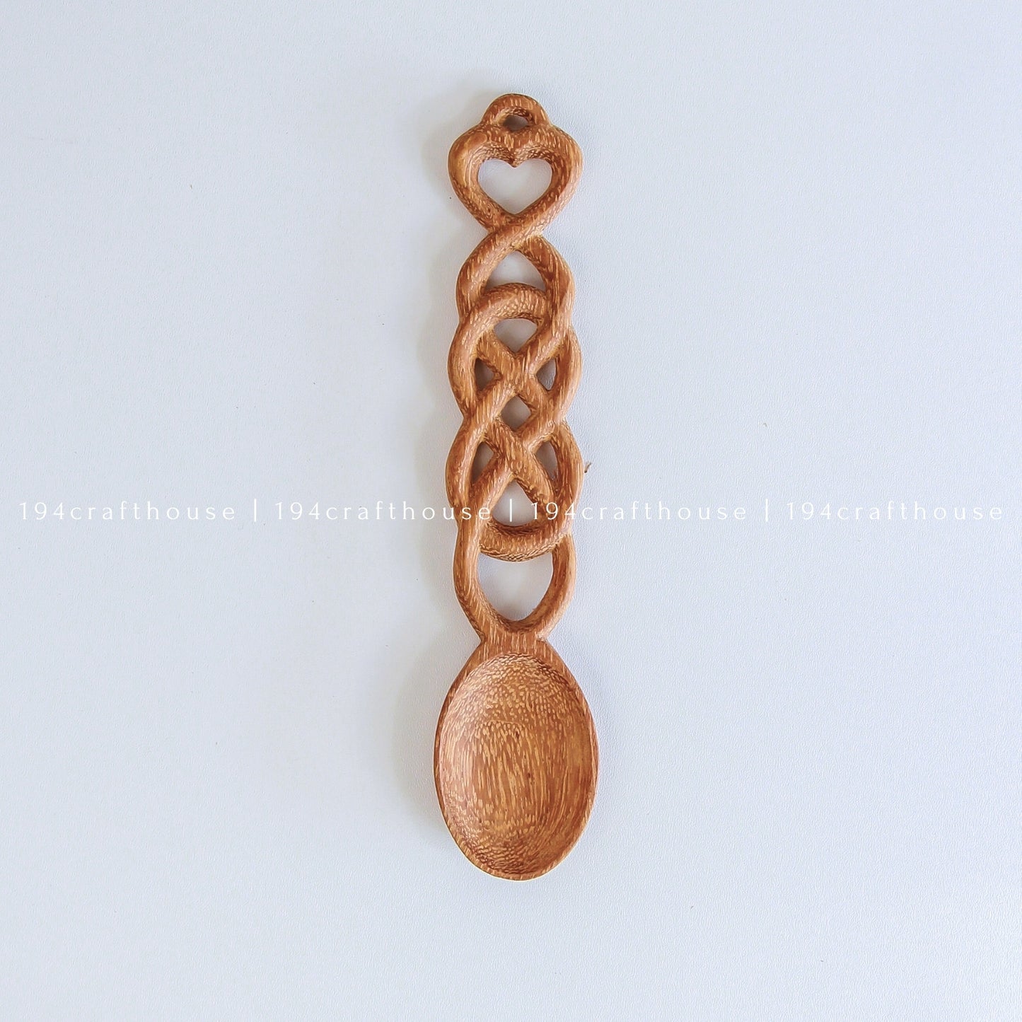 Hand-carved Welsh love spoon with a heart-shaped handle and decorative wooden chain links