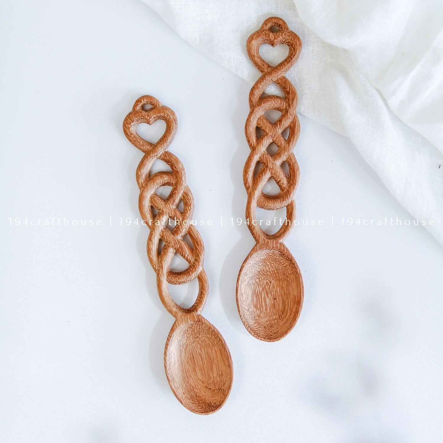 Pair of hand-carved Welsh love spoons featuring heart details and interlocking chain links
