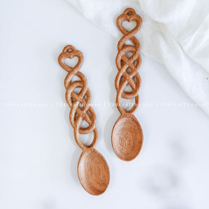 Pair of hand-carved Welsh love spoons featuring heart details and interlocking chain links