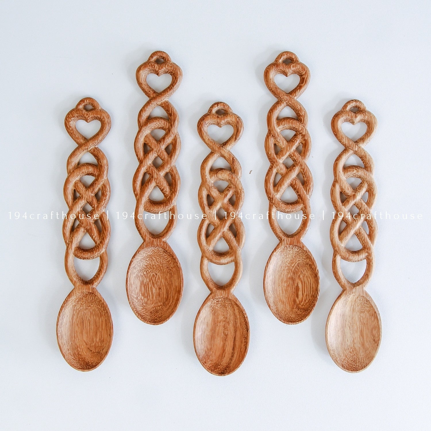 ollection of hand-carved Welsh love spoons showing natural wood grain and artisan variations