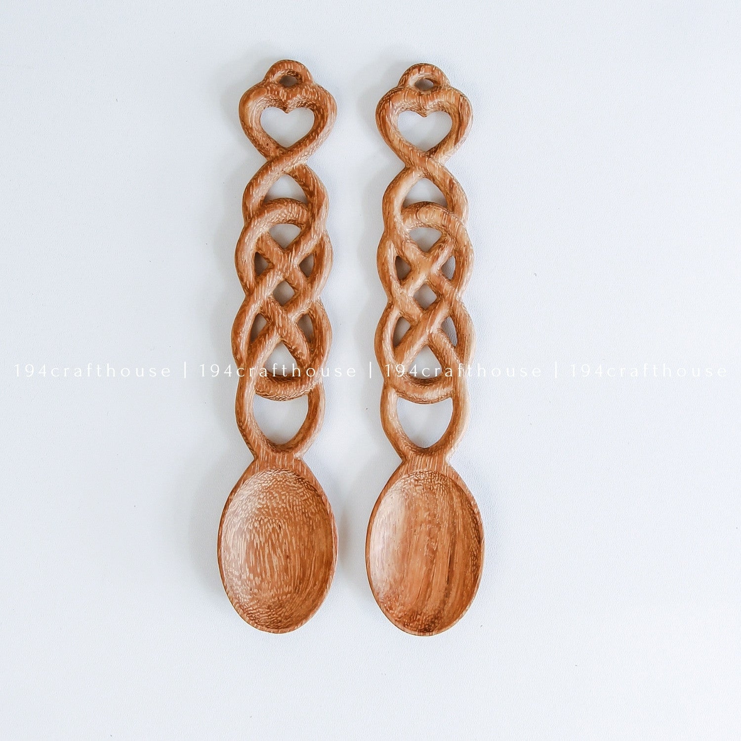 Pair of hand-carved Welsh love spoons with heart-shaped handles and decorative chain links