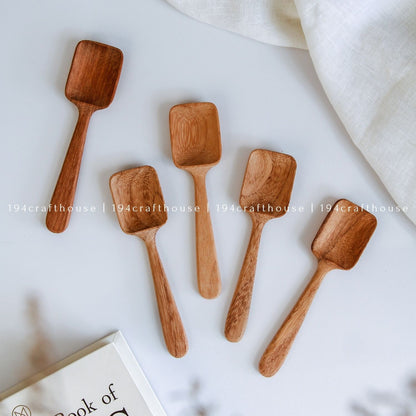 Handcarved wooden measuring spoon set showcasing natural Doussie wood grain and artisan craftsmanship
