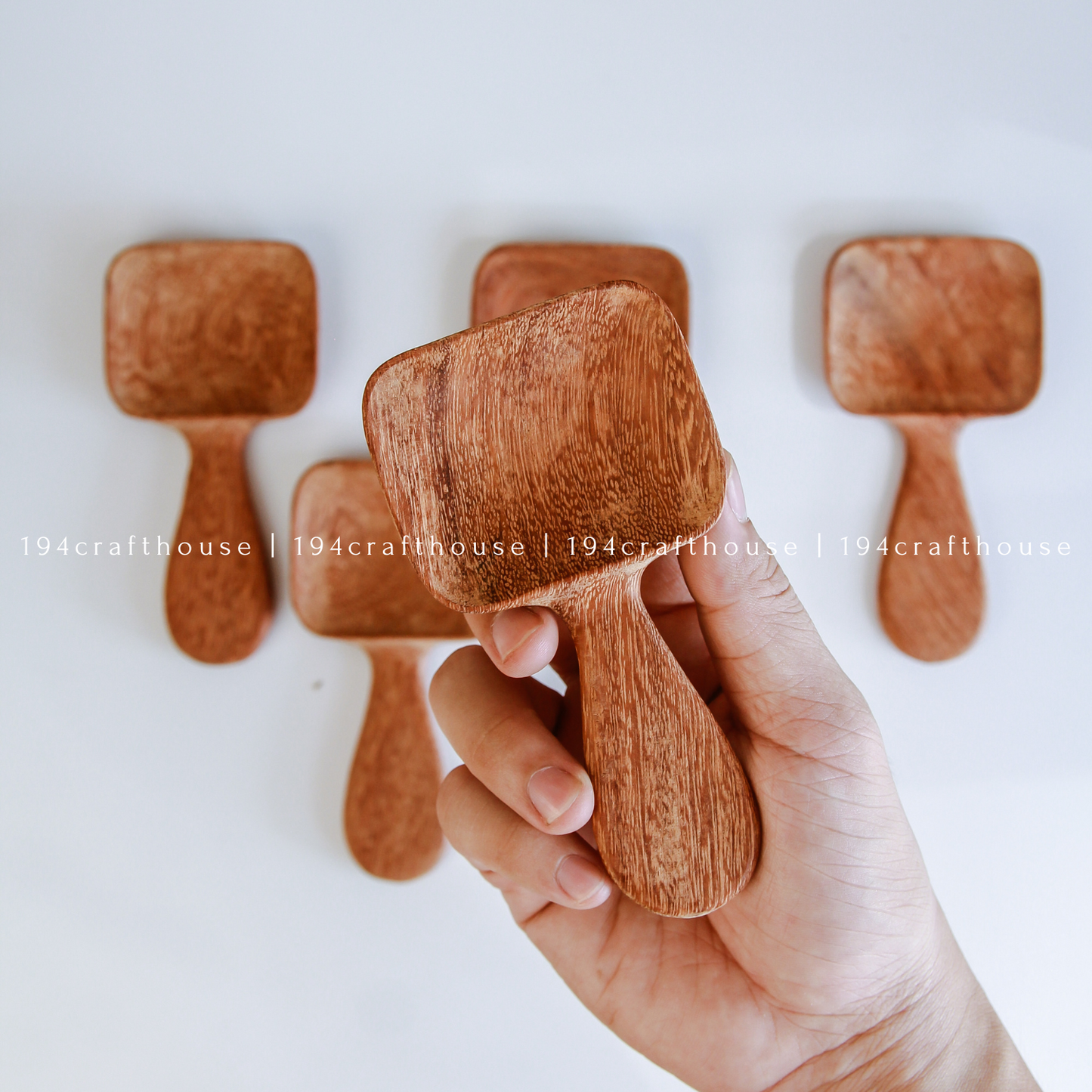 Handcarved Doussie wood measuring spoons with square scoops on a light gray background by 194 Craft House.