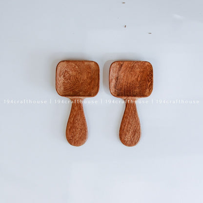 Handcarved Doussie wood measuring spoons with square scoops on a light gray background by 194 Craft House.
