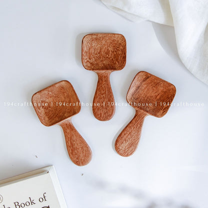 Handcarved Doussie wood measuring spoons with square scoops on a light gray background by 194 Craft House.