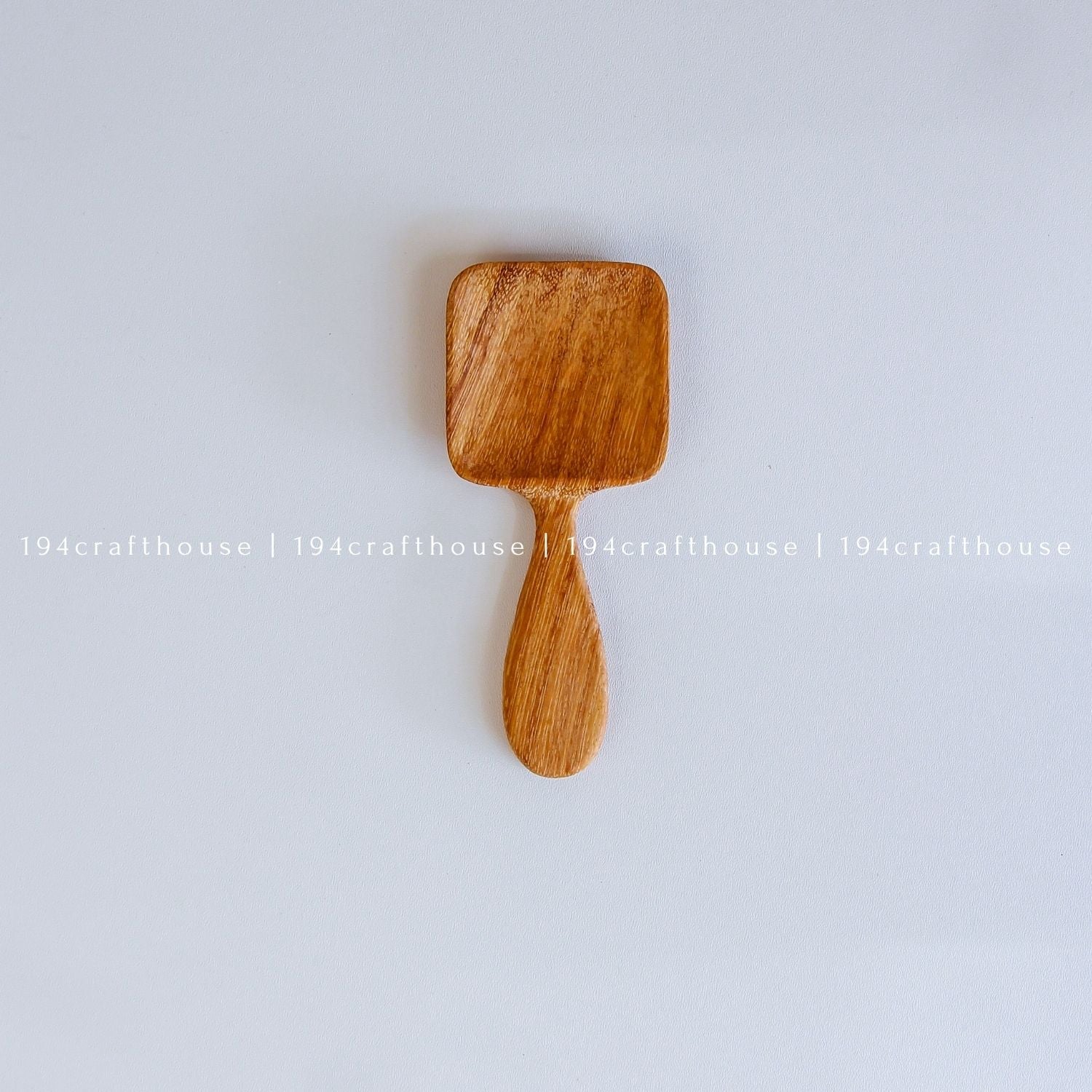 Handcarved Doussie wood measuring spoons with square scoops on a light gray background by 194 Craft House.