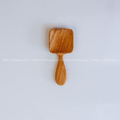 Handcarved Doussie wood measuring spoons with square scoops on a light gray background by 194 Craft House.