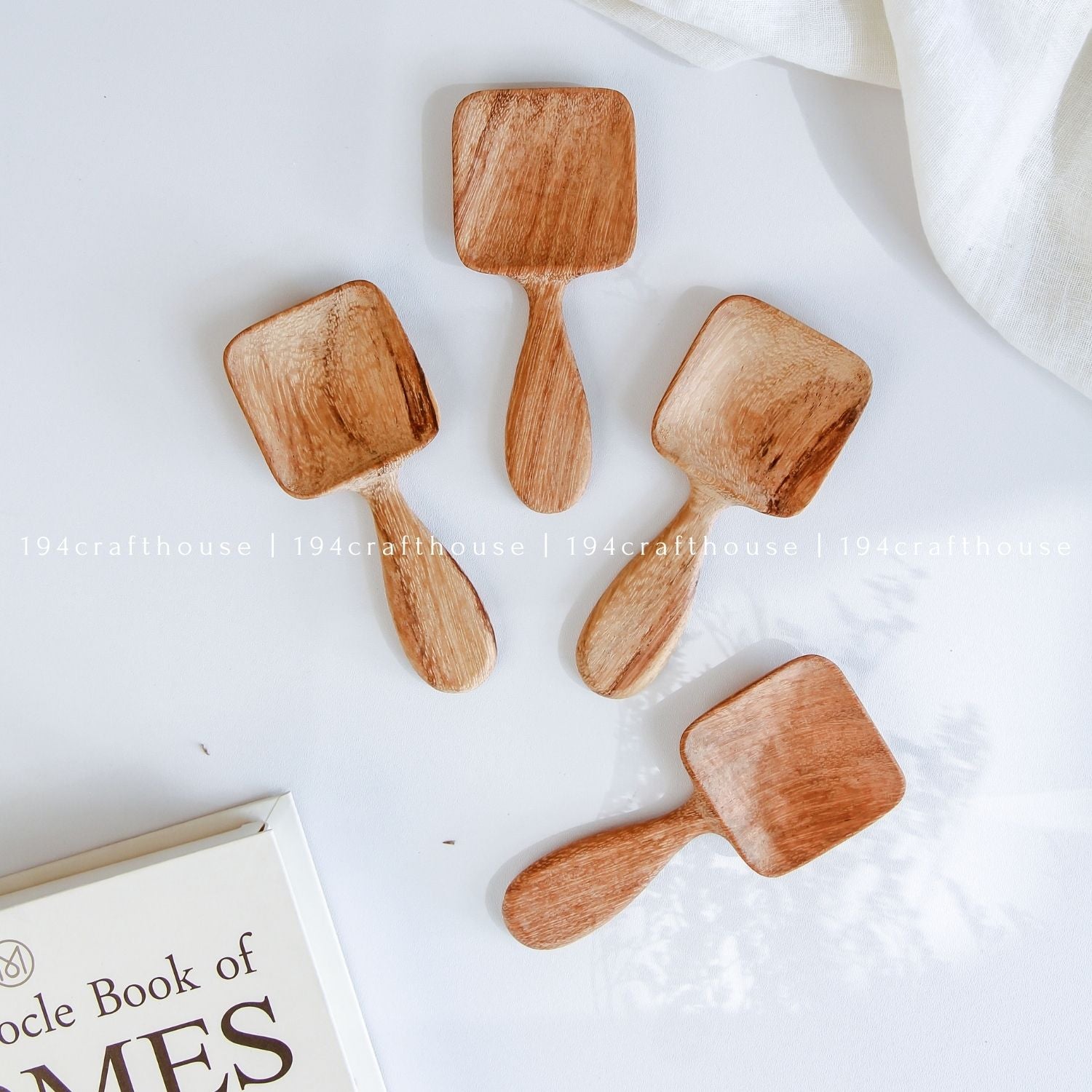 Handcarved Doussie wood measuring spoons with square scoops on a light gray background by 194 Craft House.