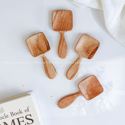 Handcarved Doussie wood measuring spoons with square scoops on a light gray background by 194 Craft House.