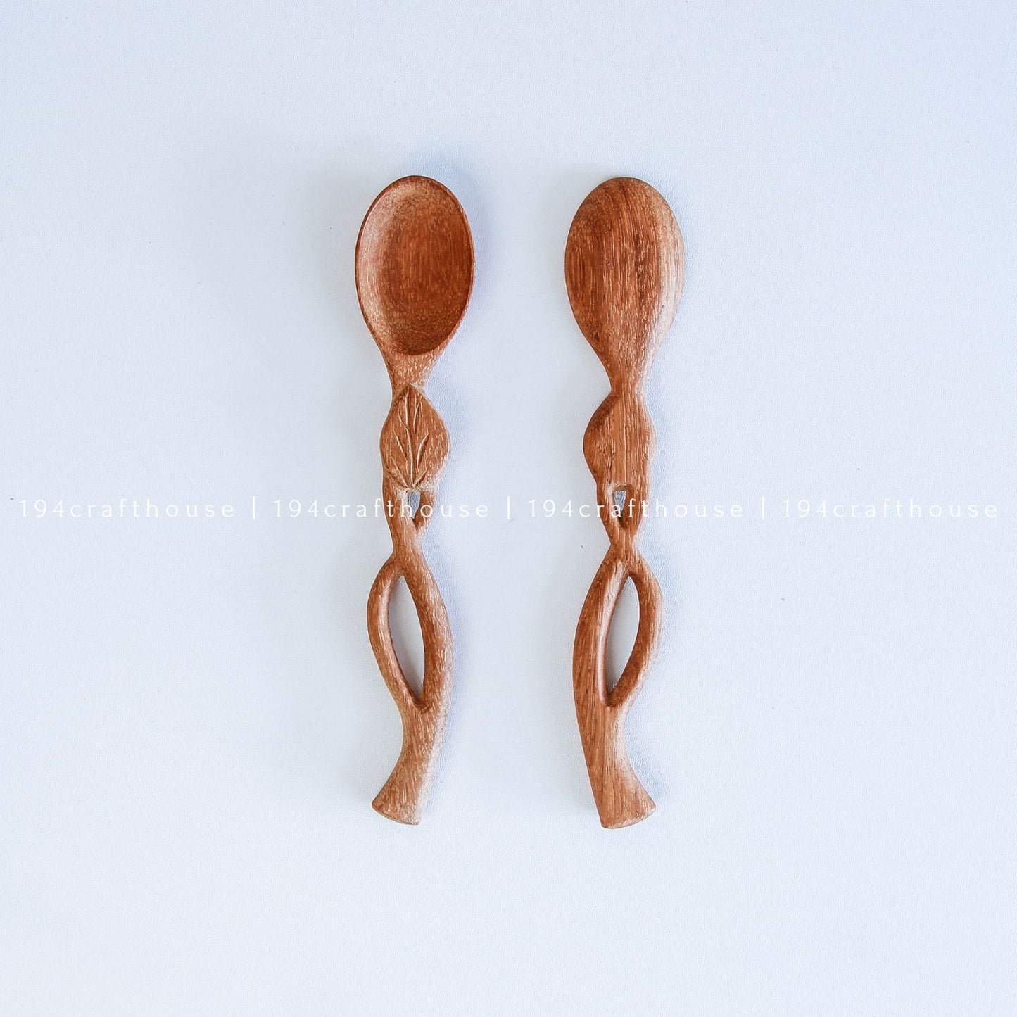 Handcarved Doussie wood measuring spoons with leaft handle on a light gray background by 194 Craft House.