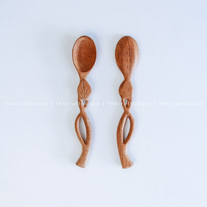 Handcarved Doussie wood measuring spoons with leaft handle on a light gray background by 194 Craft House.