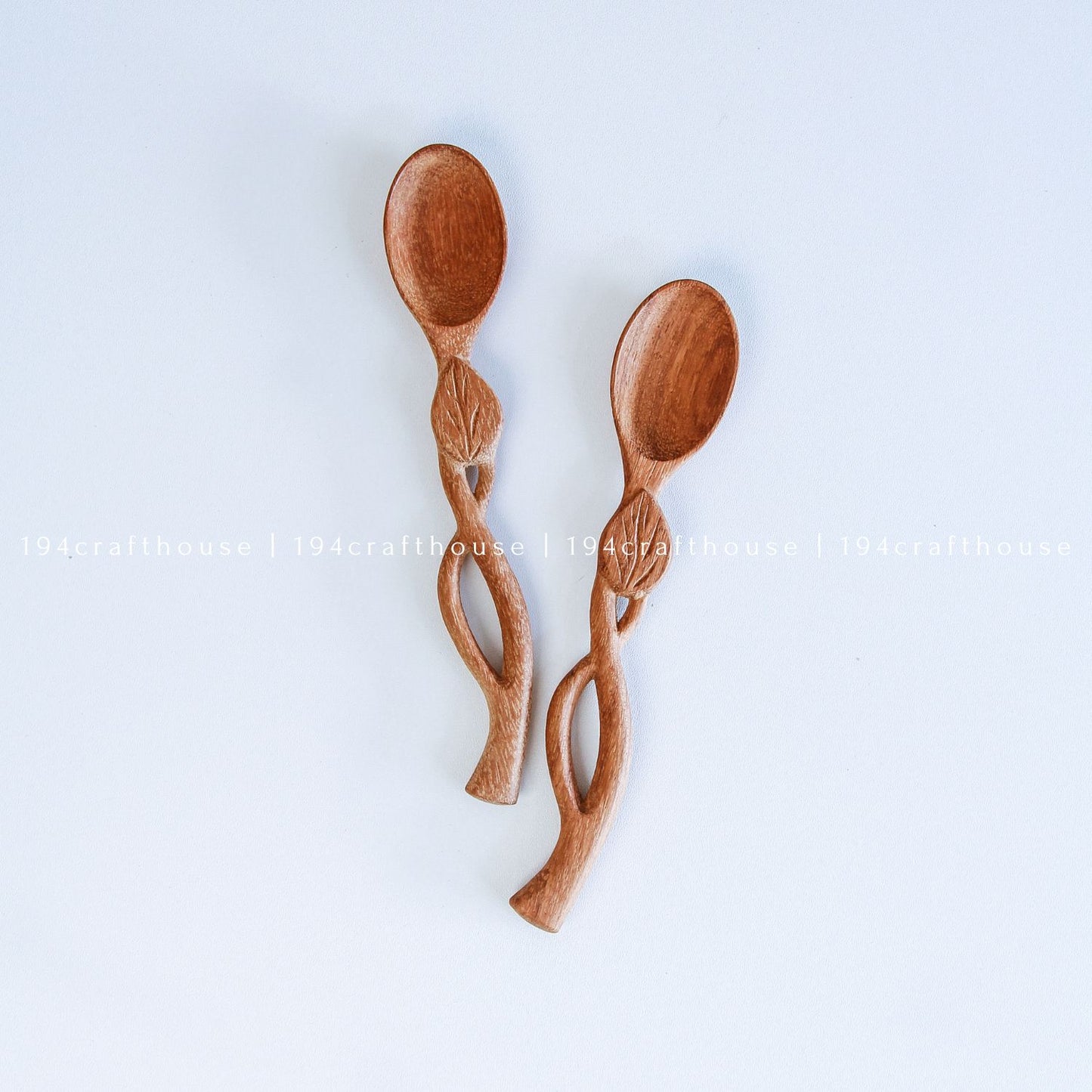 Handcarved Doussie wood measuring spoons with leaft handle on a light gray background by 194 Craft House.