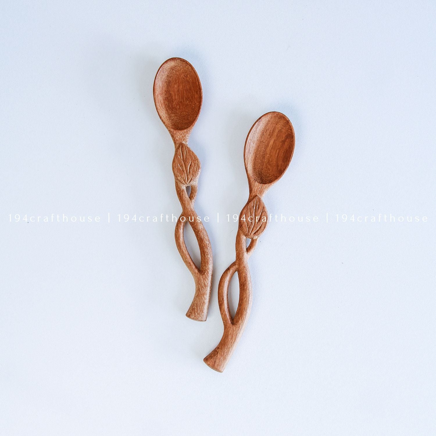 Handcarved Doussie wood measuring spoons with leaft handle on a light gray background by 194 Craft House.