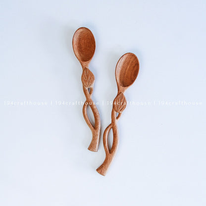 Handcarved Doussie wood measuring spoons with leaft handle on a light gray background by 194 Craft House.
