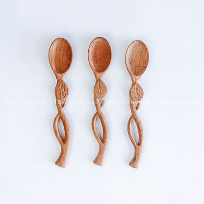 Handcarved Doussie wood measuring spoons with leaft handle on a light gray background by 194 Craft House.