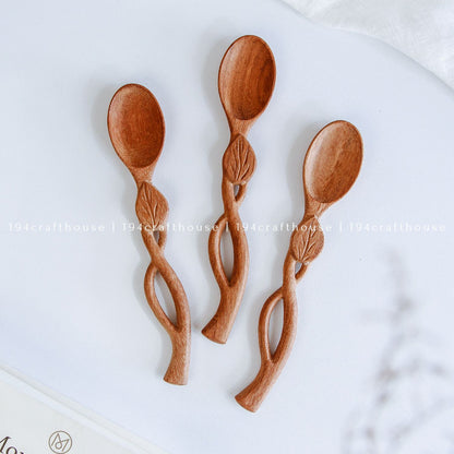 Handcarved Doussie wood measuring spoons with leaft handle on a light gray background by 194 Craft House.