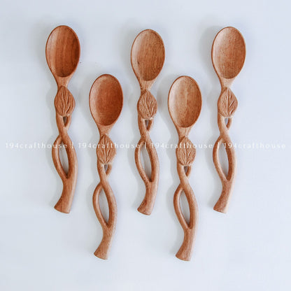 Handcarved Doussie wood measuring spoons with leaft handle on a light gray background by 194 Craft House.