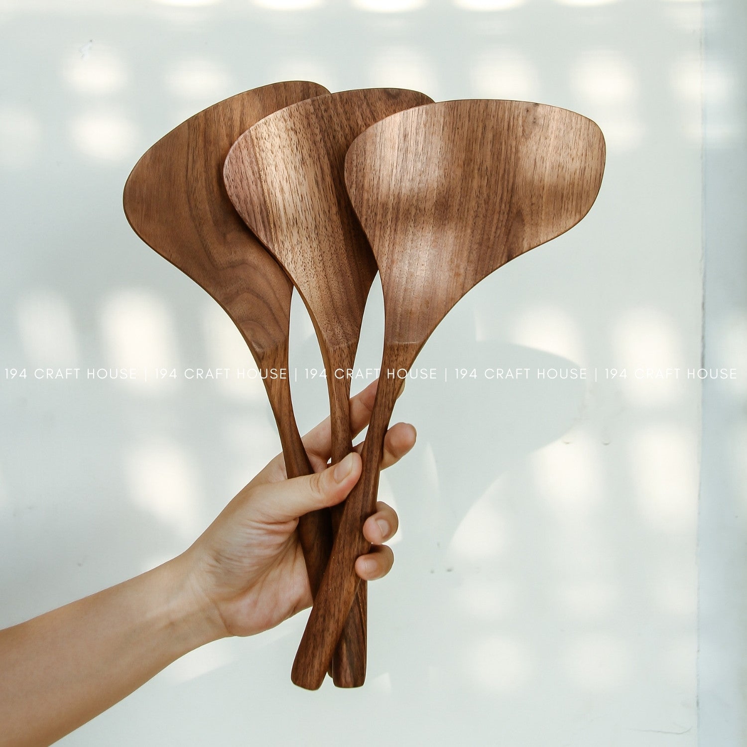 Three wooden spoons held by a hand against a light background with 'Lina Craft House' branding.