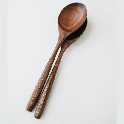 Two walnut spoons arranged together, showing their rounded bowls and engraved handles