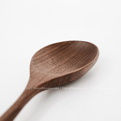 Handcrafted large walnut wooden serving spoon with a deep bowl and distinctive natural wood grain