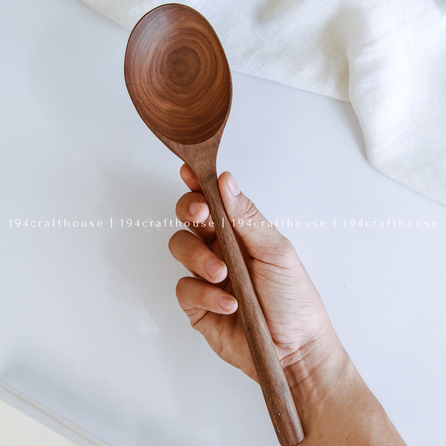 Large 12-inch walnut wooden serving spoon held in hand to show its size