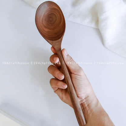 Large 12-inch walnut wooden serving spoon held in hand to show its size
