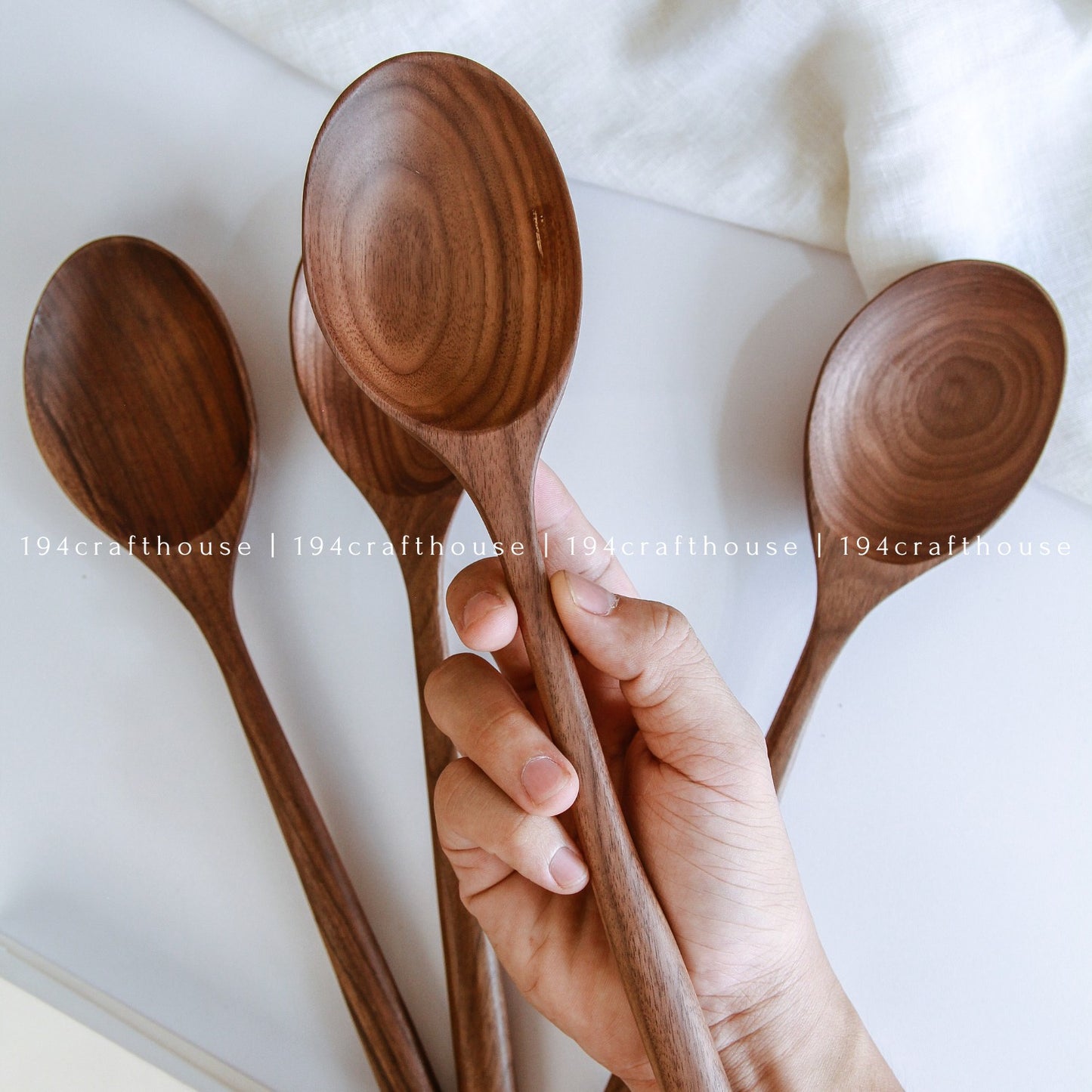Handcrafted walnut wooden serving spoon with a broad spoon head and long handle