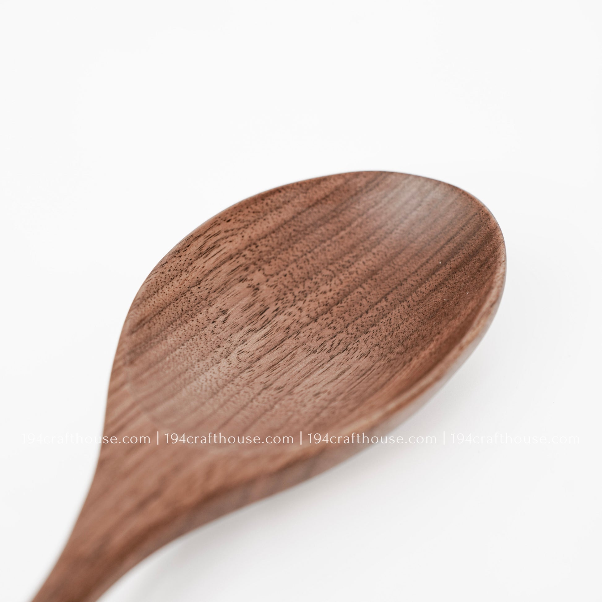 Close-up of a large walnut wooden spoon bowl showing rich natural grain and smooth handcrafted finish
