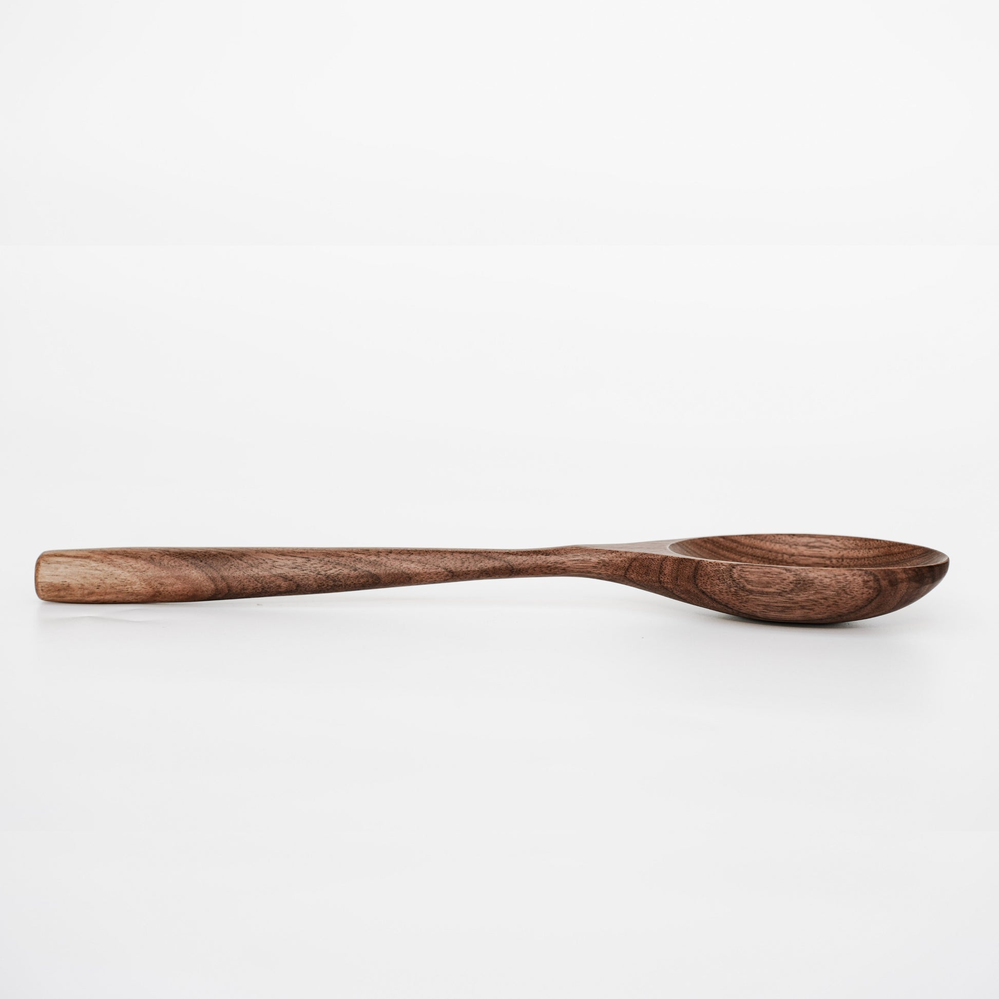 Handmade walnut wooden spoon with natural wood grain, eco-friendly kitchen utensil