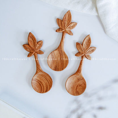 Three wooden spoons with leaf designs on a white background