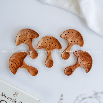Top-down view of a five of hand-carved Doussie wood mushroom spoon centered on a smooth white surface, handmade by 194 Craft House