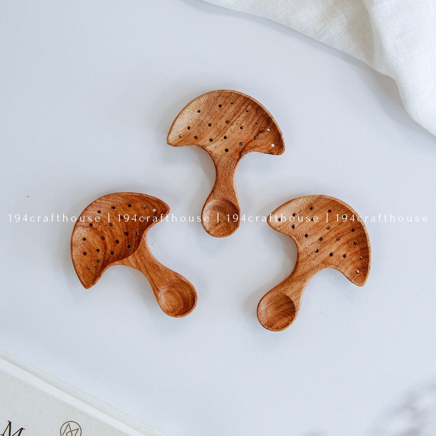 Hand-carved Doussie wood spoon featuring a detailed mushroom cap handle on a seamless white background.