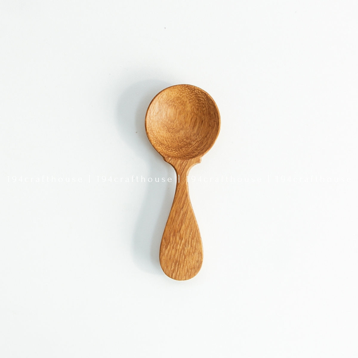 Single wooden spice measuring spoon displayed vertically on a white background