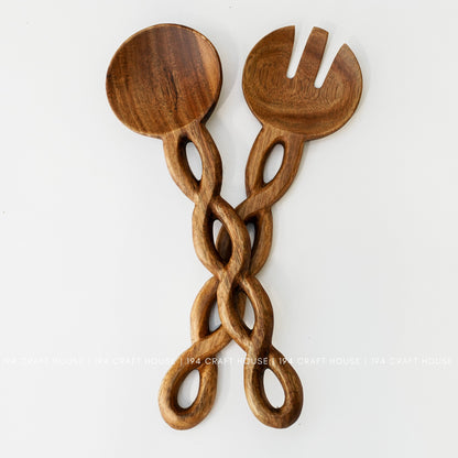Back view of a handcrafted wooden salad server set with carved chain-link handles