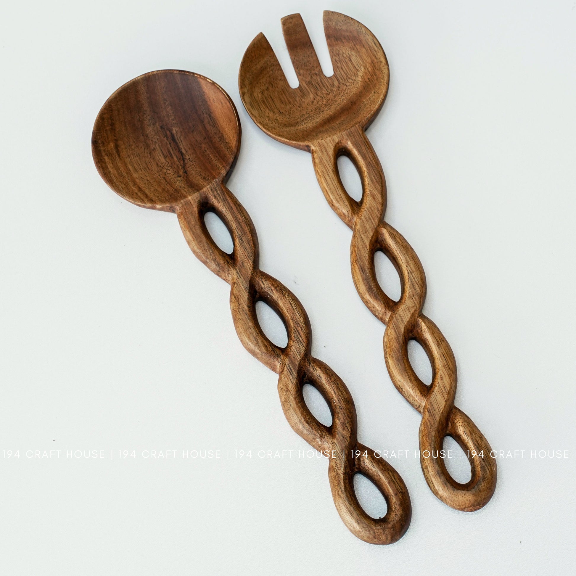 Front view of a handcrafted wooden salad spoon and fork set with decorative chain-link handles