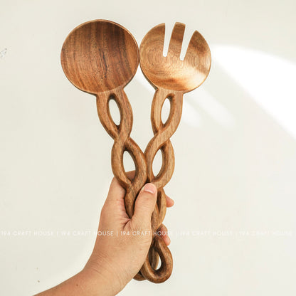 Handcrafted chain-handle wooden salad servers held in hand to show their size and artisan details