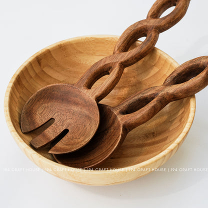 Handcrafted chain-handle wooden salad servers displayed in a wooden serving bowl