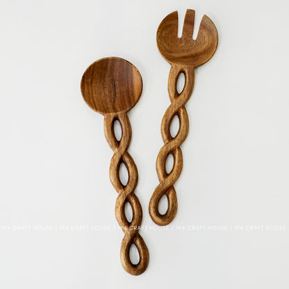 Serving spoon and fork-shaped utensil displayed upright side by side against a light background.