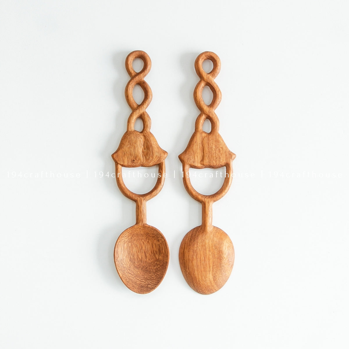 Two Doussie wood spoons side by side, showing differences in natural grain and carved handle details.