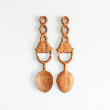 Two Doussie wood spoons side by side, showing differences in natural grain and carved handle details.