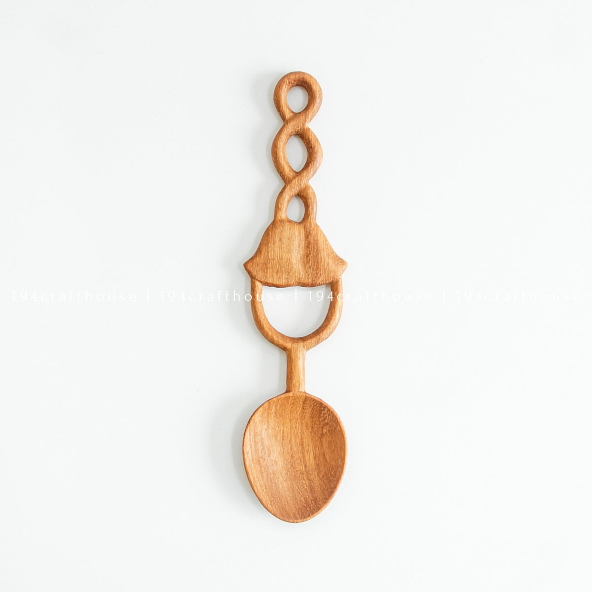 Single Doussie wood spoon on a pale background, showing the full bell-shaped carved loop handle and rounded bowl.