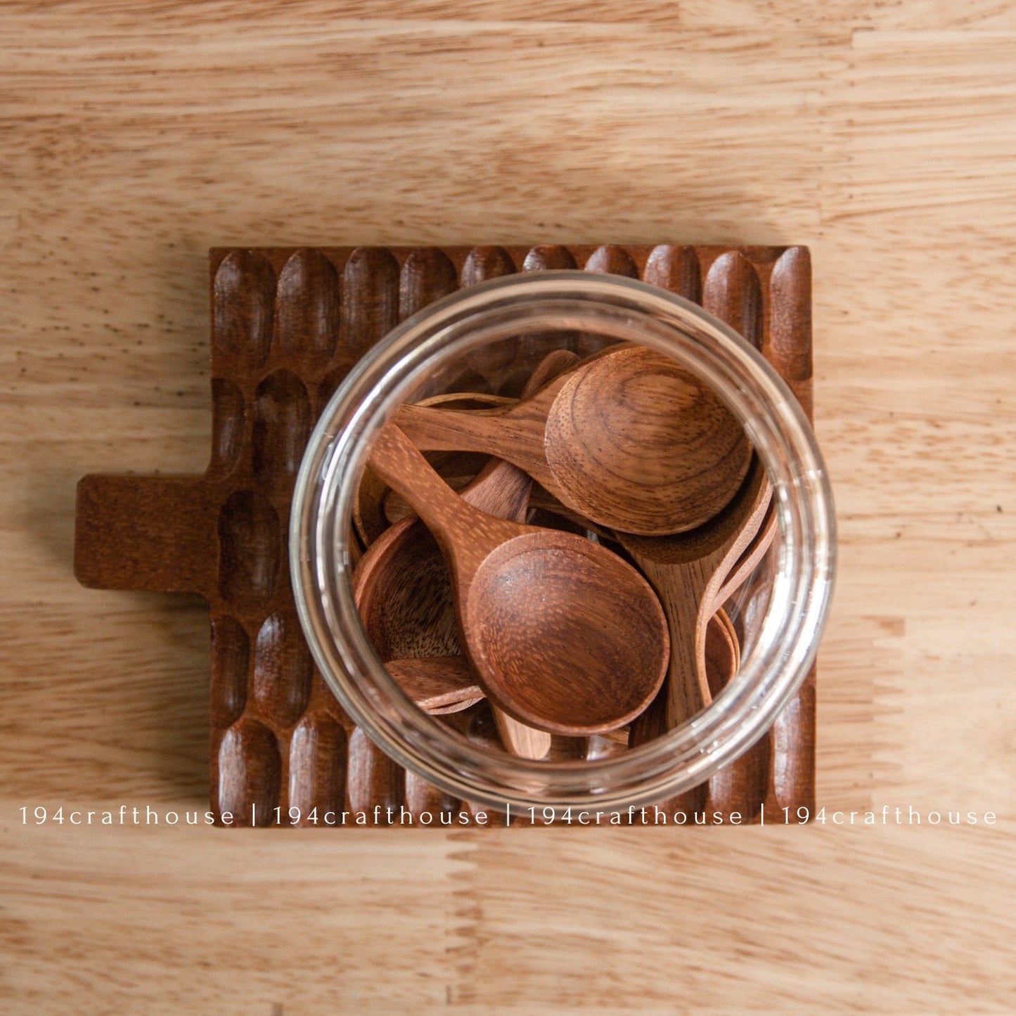 Mini wooden spoon inside a glass spice jar for scooping salt, sugar, herbs, and seasonings