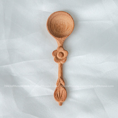Handcrafted wooden spice spoon with a decorative flower-shaped handle and smooth natural finish