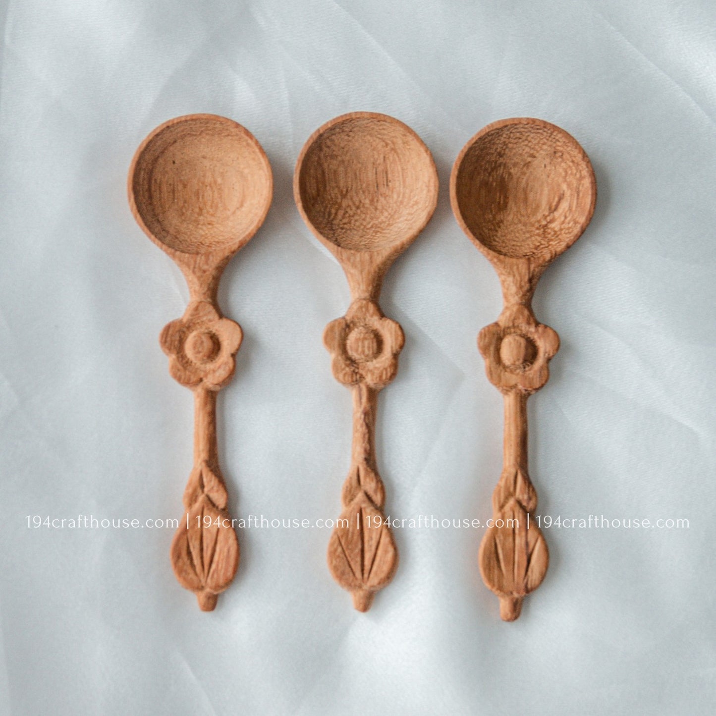 Set of three handcrafted wooden spice spoons with decorative flower handles and natural wood grain