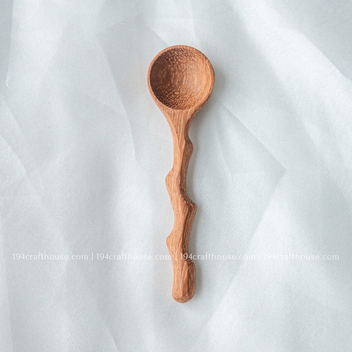 Handcrafted wooden spice spoon with a rustic branch-inspired handle and smooth natural finish