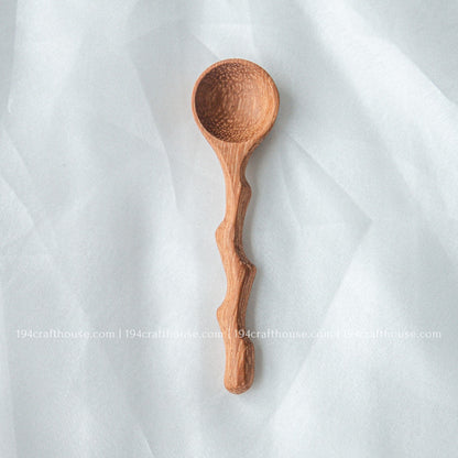 Handcrafted wooden spice spoon with a rustic branch-inspired handle and smooth natural finish