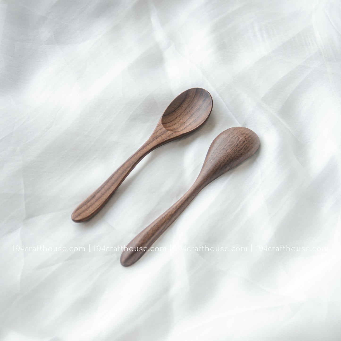 Two handcrafted 6-inch walnut wooden spoons displayed at an angle, showcasing their natural walnut wood grain and smooth finish