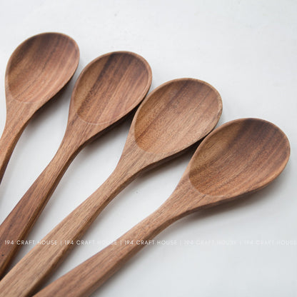Close-up of four acacia wood salad spoon bowls showing fine grain and smooth edges