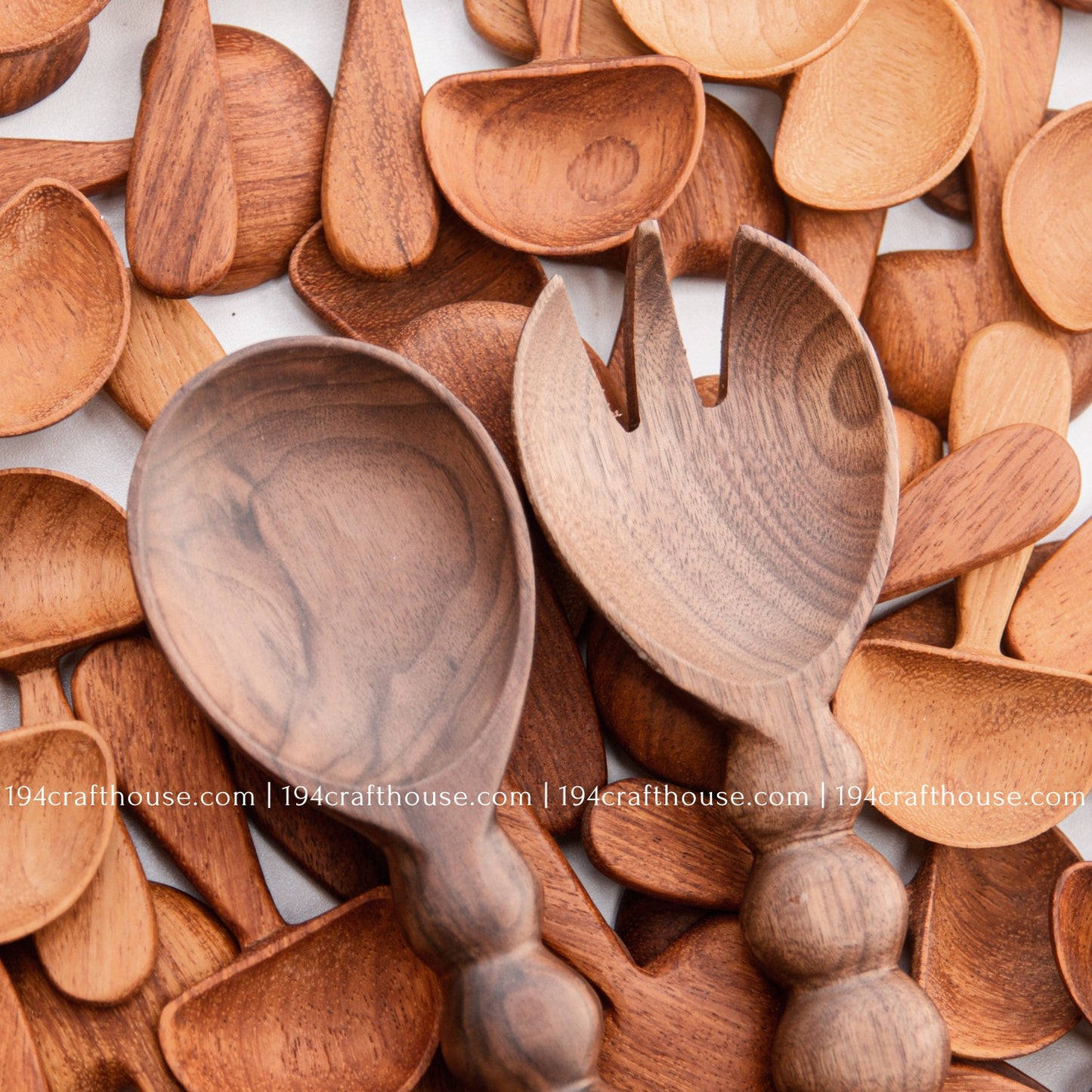 Handcrafted walnut wood salad servers with beaded handles, featuring a serving spoon and fork set on mushroom wood spoon background by 194 Craft House.